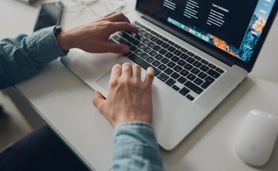 person wearing long-sleeve top working on laptop