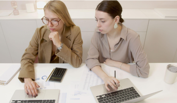 two women with laptops
